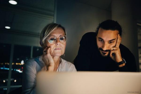 Woman and man staring at a laptop screen